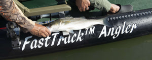 Angler holding a striped bass on a black Sea Eagle FastTrack™ inflatable kayak with a measuring ruler.