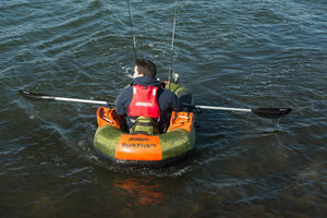 Man in an orange and green PackFish7™ inflatable boat, rowing with 5' aluminum and ABS plastic oars.