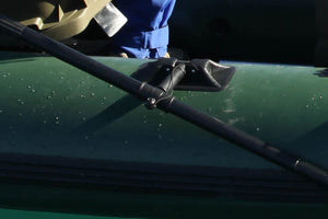 Black Sea Eagle oarlock with a tall pin, securing a black oar to a green inflatable boat.