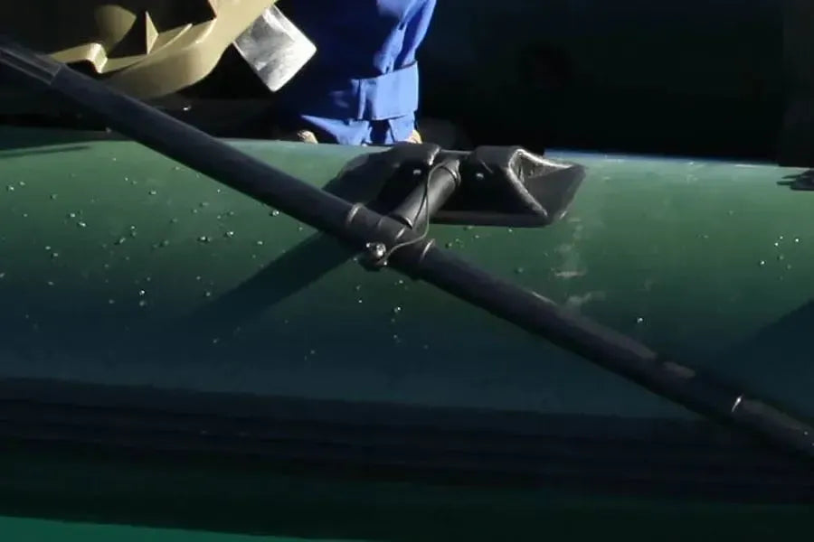 Black Sea Eagle oarlock with a tall pin, securing a black oar to a green inflatable boat.