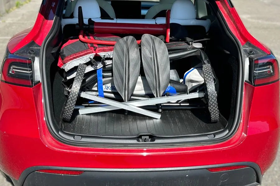 Sea Eagle EZ Cart (small) with gray frame and black wheels, packed in a red car trunk with paddles.