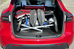 Sea Eagle EZ Cart (small) with gray frame and black wheels, packed in a red car trunk with paddles.
