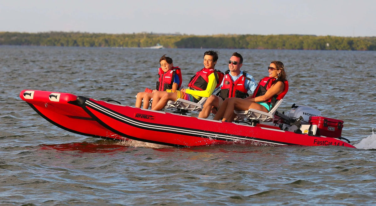Red Sea Eagle FastCat14 inflatable catamaran with four people in life vests on open water.