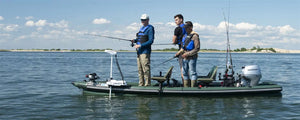 Three men fishing from a green Sea Eagle FishSkiff 16 inflatable boat with a Honda outboard motor.
