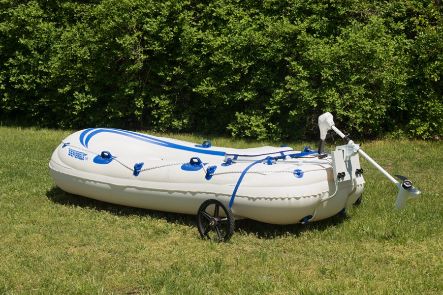 White Sea Eagle inflatable boat with blue stripes, featuring a heavy-duty EZ Cart wheel system on green grass.