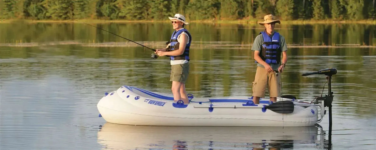 Two men fishing from a white and blue Sea Eagle 9 inflatable boat with an electric motor on a calm lake.