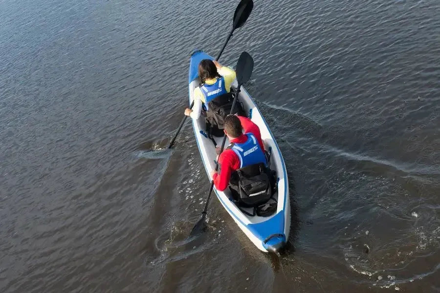 Two people in a blue and white inflatable kayak with black Tall Back Kayak Seats and paddles.
