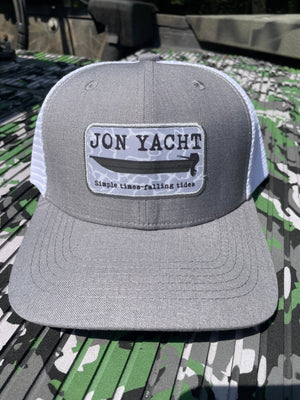 Gray and white trucker hat with "JON YACHT" patch featuring a boat and "Simple times-falling tides.