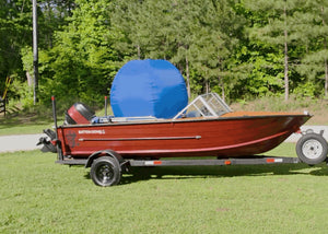 Red boat on a trailer with a large, blue, inflatable SwellUP boat cover support system.