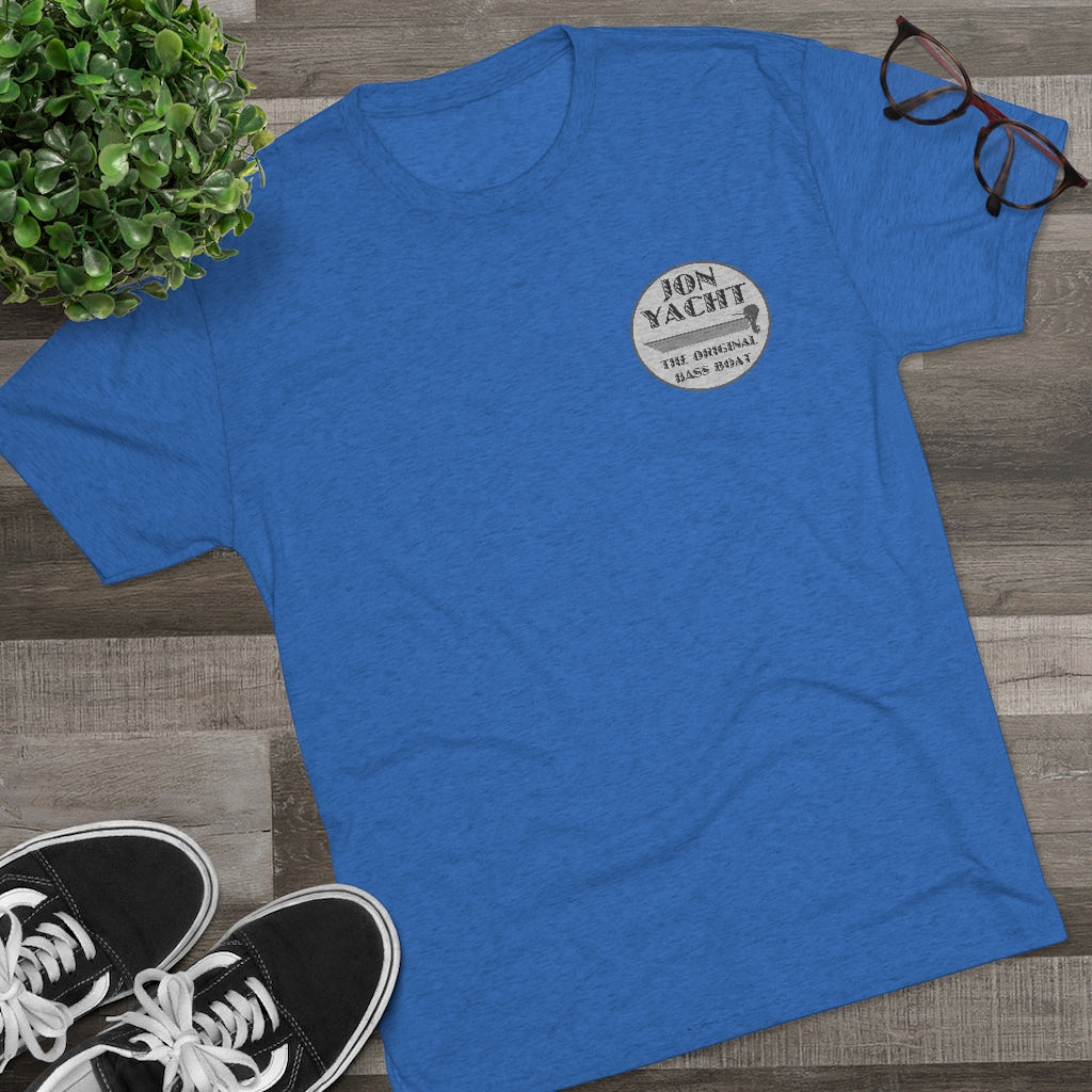 Blue tri-blend regular fit t-shirt with "Jon Yacht The Original Bass Boat" logo, black sneakers, plant, and glasses.