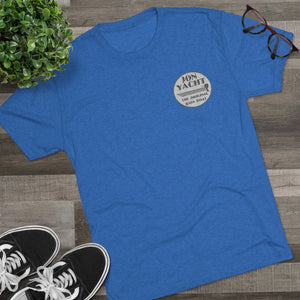 Blue tri-blend regular fit t-shirt with "Jon Yacht The Original Bass Boat" logo, black sneakers, plant, and glasses.