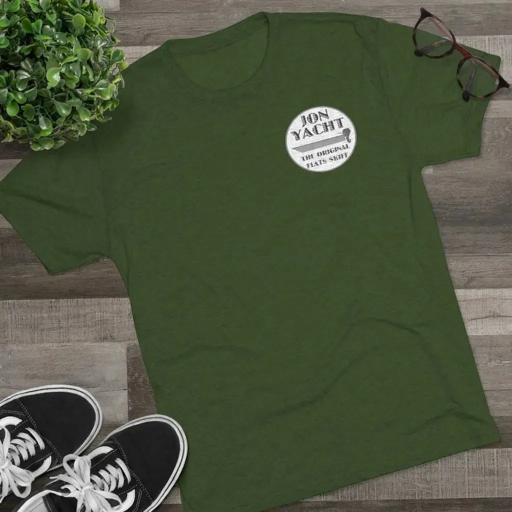 Dark green "Jon Yacht The Original Flats Skiff" graphic tee, soft cotton, with black sneakers and glasses.