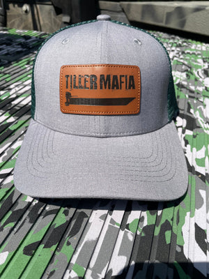 Gray and dark green trucker hat with a brown leather patch featuring "Tiller Mafia" and a boat graphic.
