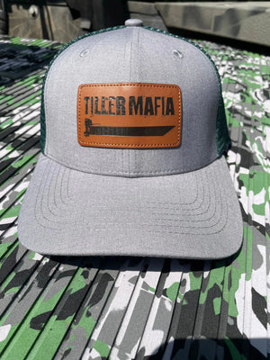 Gray and dark green trucker hat with a brown leather patch featuring "Tiller Mafia" and a boat graphic.