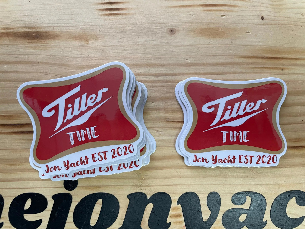 Red and white "Tiller Time" 3" stickers with gold trim and "Jon Yacht EST 2020" text on wood.