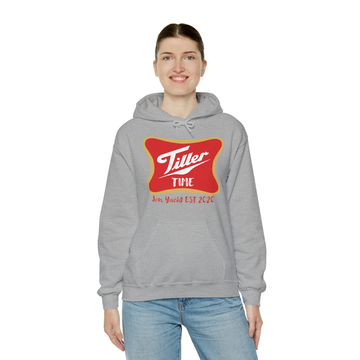 Woman smiling in a grey Tiller Time hoodie with a red and gold graphic, kangaroo pocket, and drawstring hood.