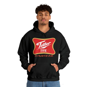 Young man in a black Tiller Time hoodie with red and gold logo, kangaroo pocket, and matching drawstring.