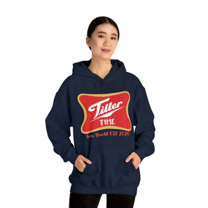 Woman wearing a navy "Tiller Time" hoodie with a red and gold logo, featuring a kangaroo pocket.
