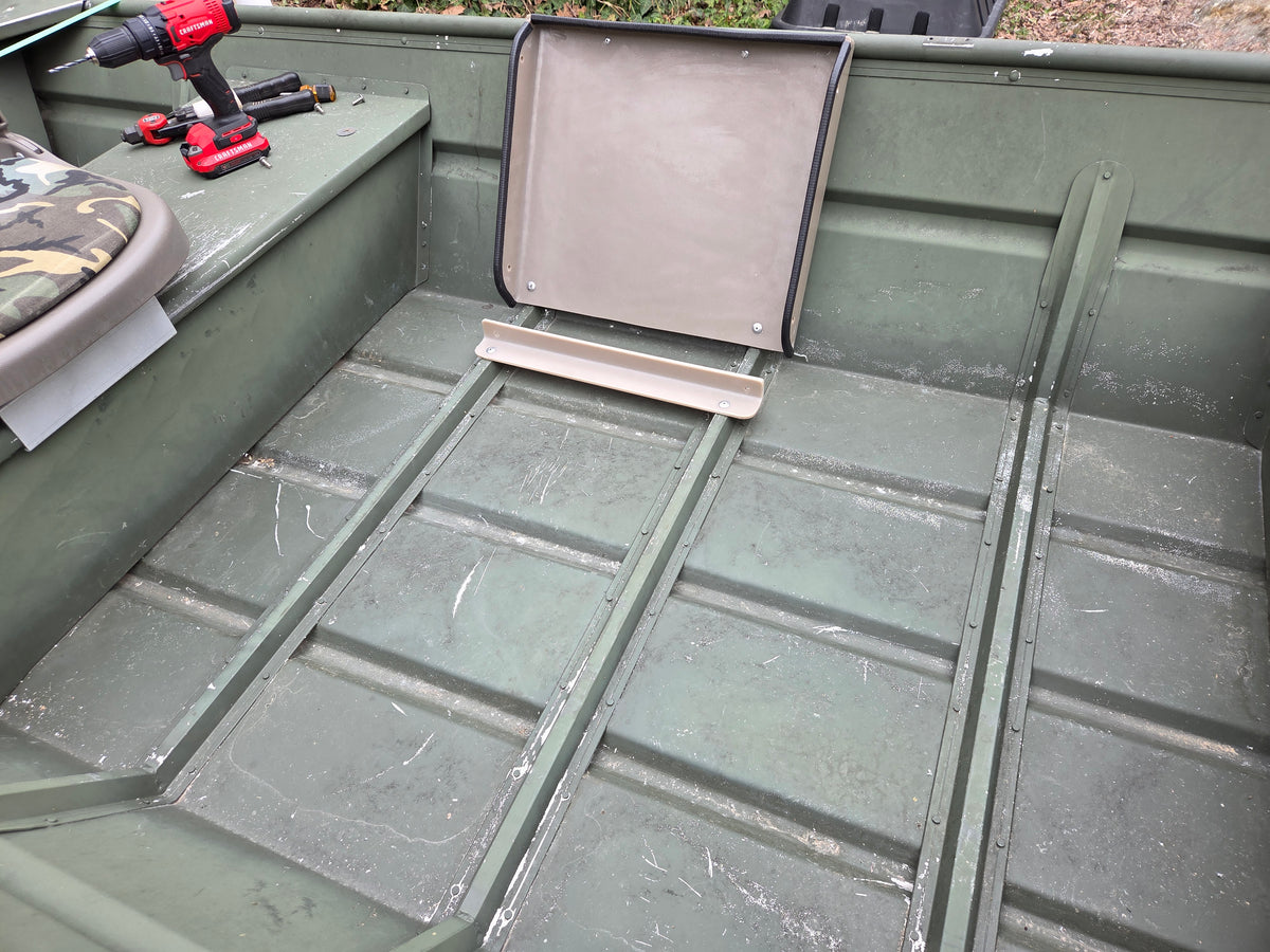 Empty olive green jon boat interior with a beige tiller console and seat back.