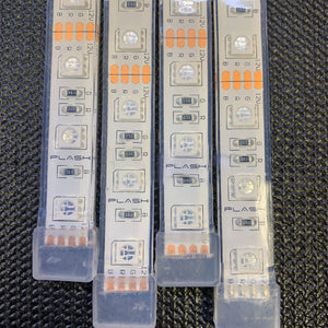 Close-up of four waterproof flexible RGB LED light strips with clear silicone casing and visible circuitry.
