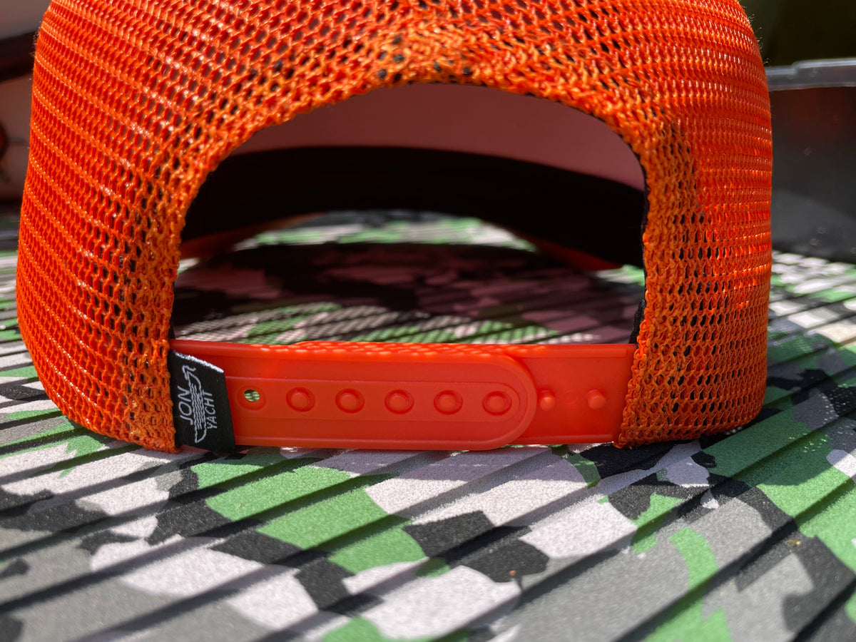 Bright orange mesh trucker hat with a snapback closure and a black "JON YACHT" tag.