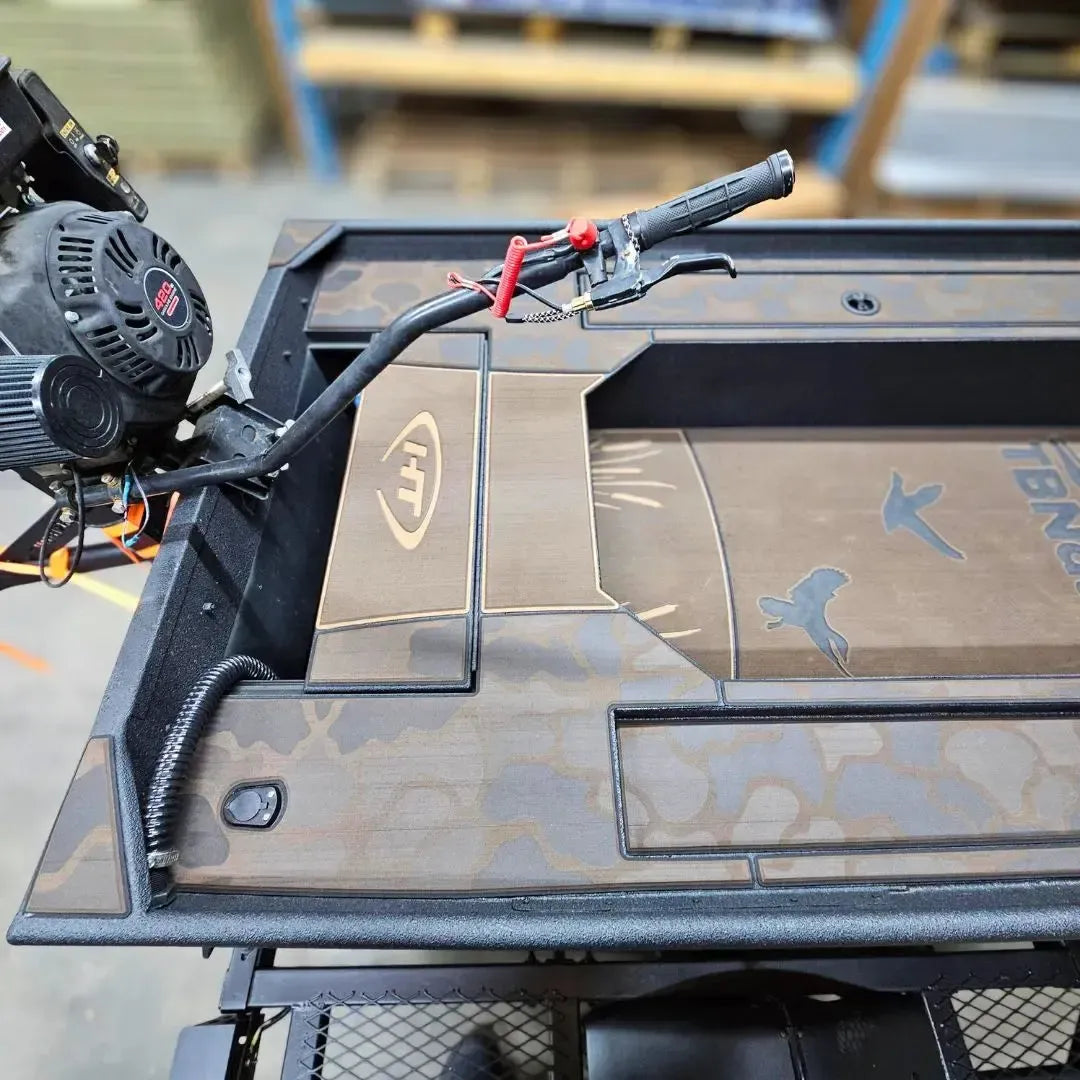 Custom 1436 duck boat with espresso over black paint, camo HydroTurf, and a mud motor.