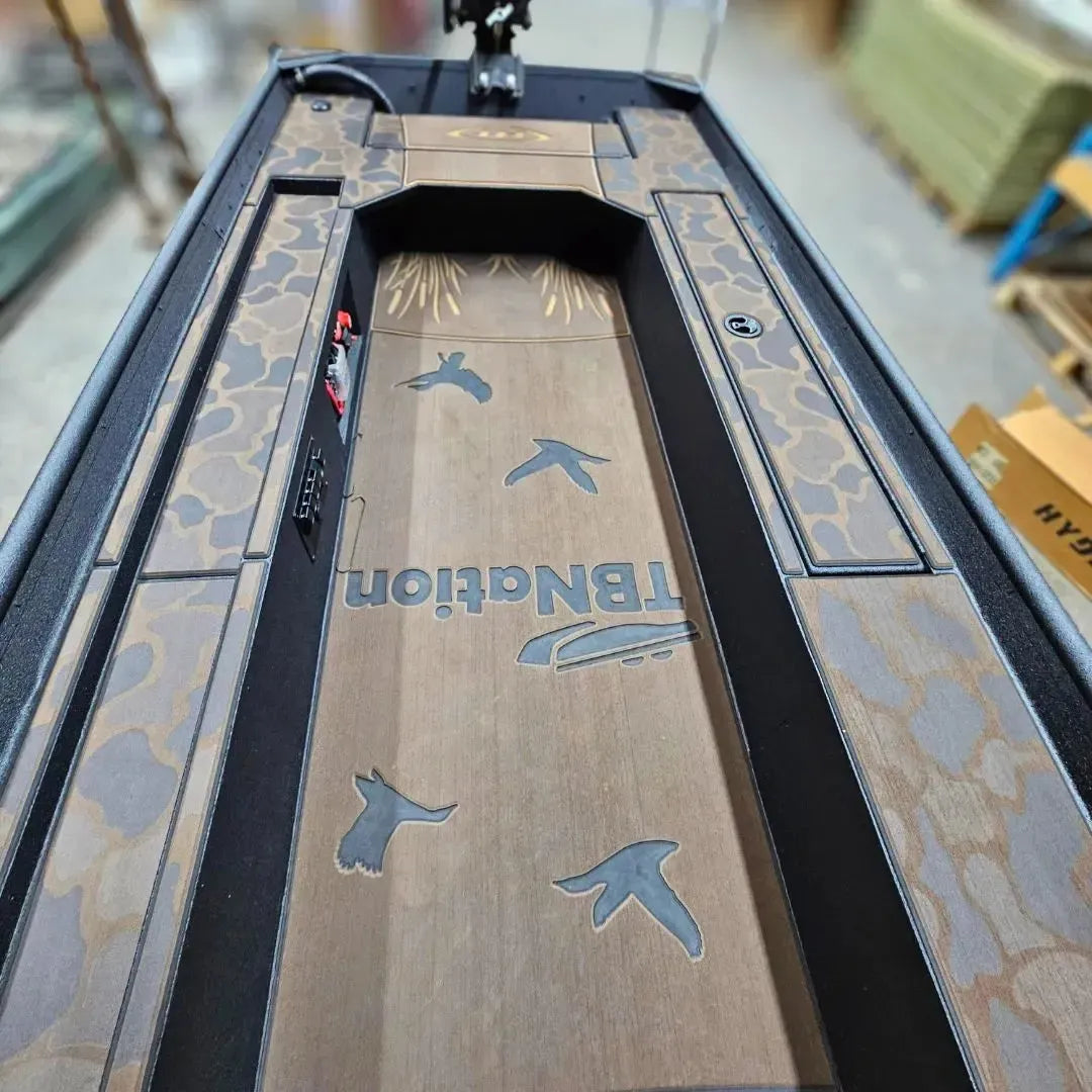 Custom 1436 duck boat deck with espresso over black camo HydroTurf, laser-engraved ducks, and "TBNation" logo.