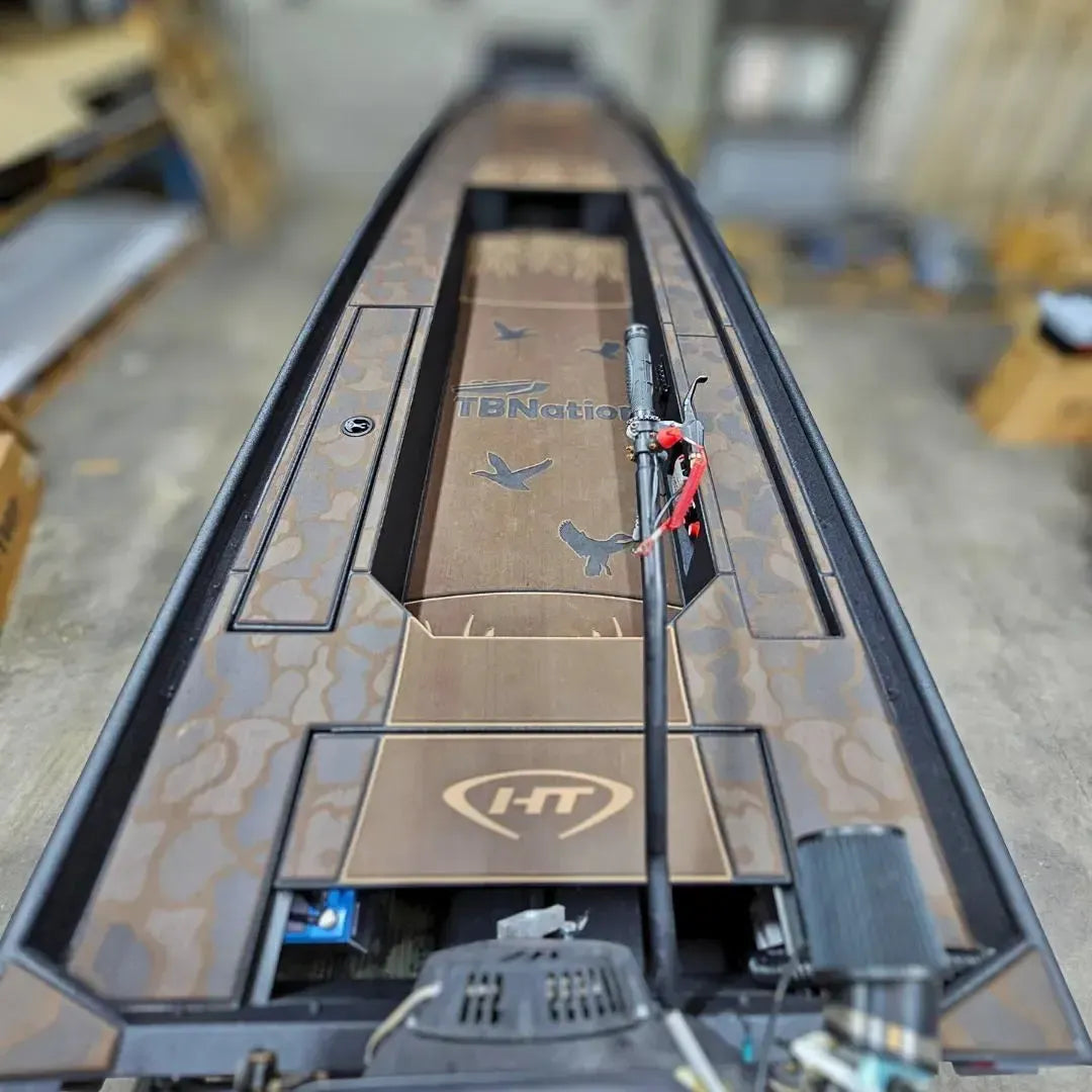 Custom 1436 duck boat with espresso over black paint, camo HydroTurf, and mud motor.