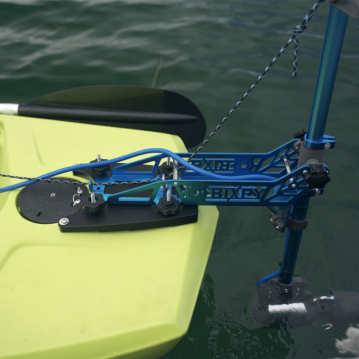 Kayak with a blue motor attached to the back, floating on water.