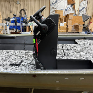 Black metal lever or handle on a workbench with boxes and equipment in the background