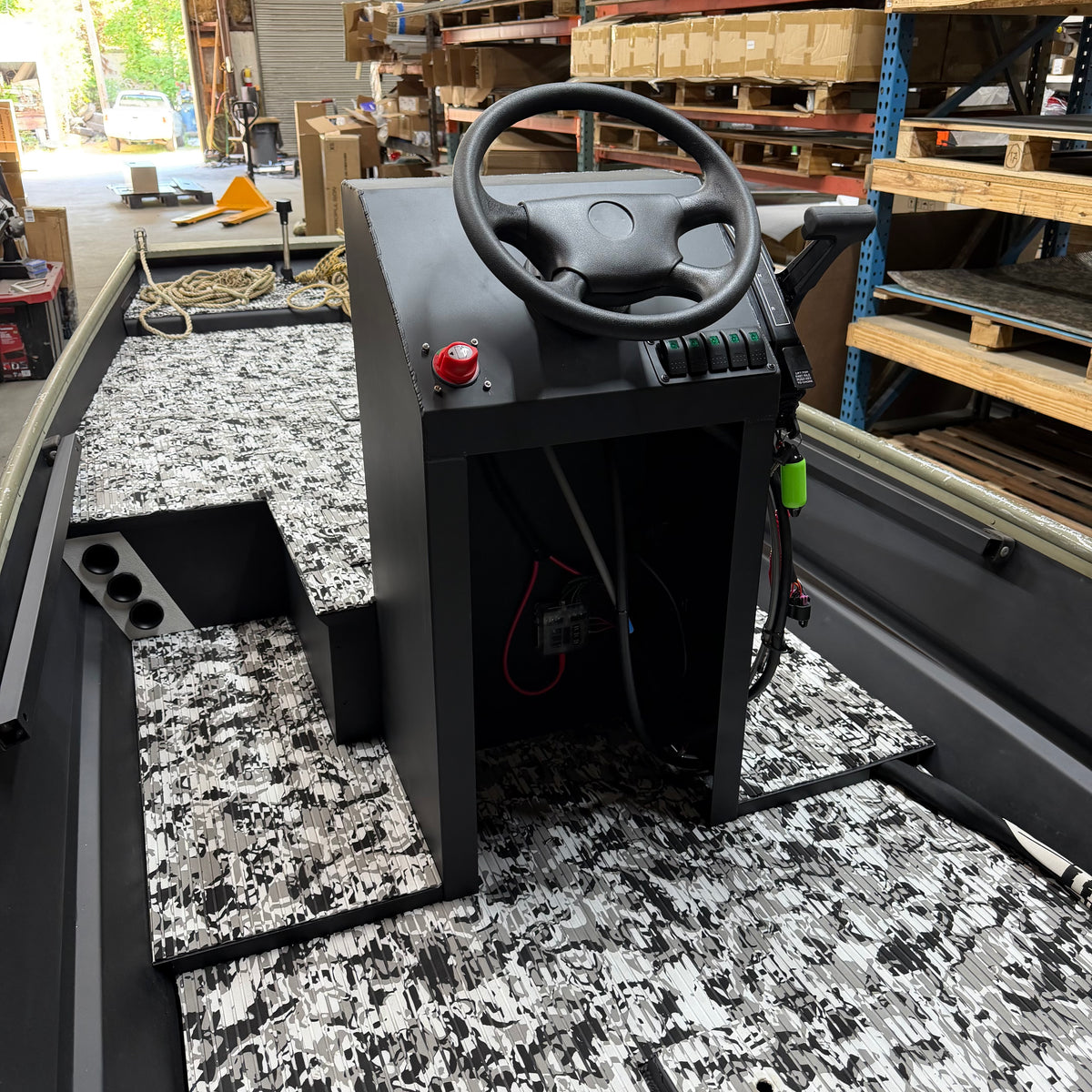 Control panel with steering wheel and buttons in a warehouse setting