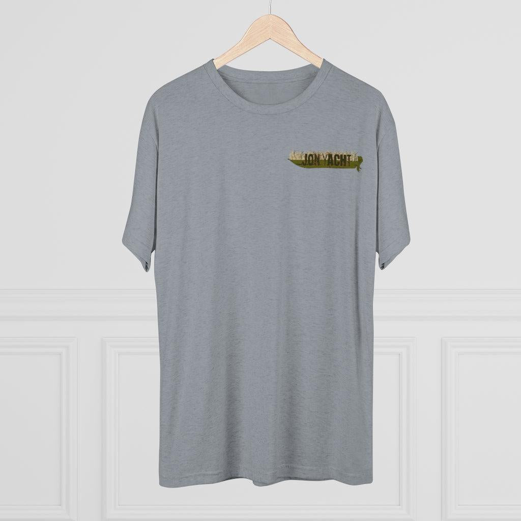 A heather gray short-sleeve crewneck t-shirt hanging on a light wood hanger against a white paneled wall. The shirt features a small graphic on the left chest depicting a gold foil-like envelope with the text 'JON YACHT'.