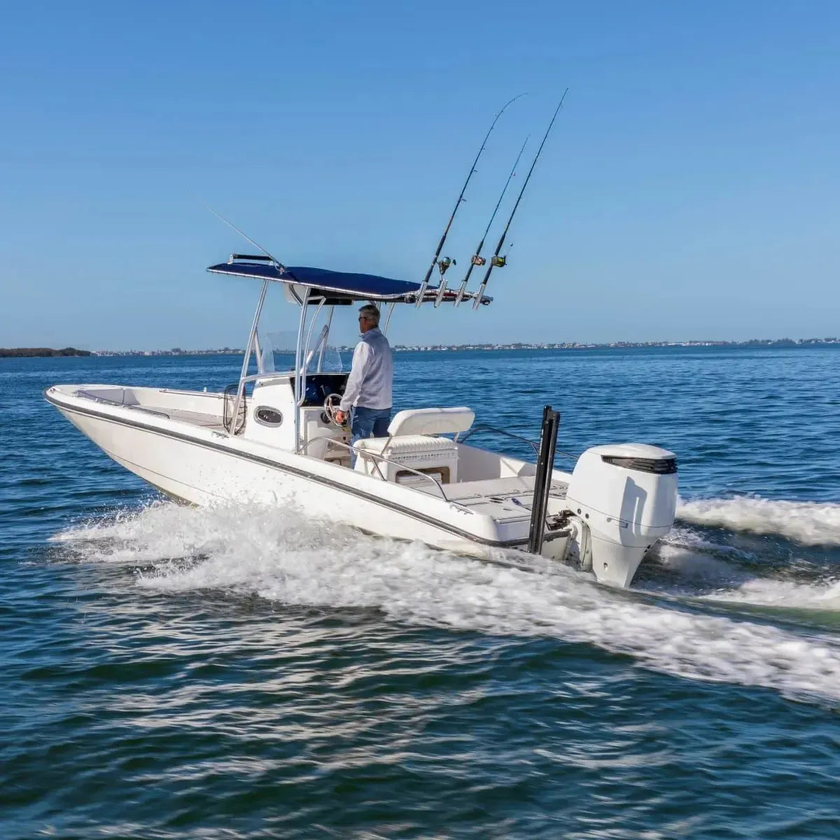 White Lewmar Axis electric shallow water anchor mounted on the transom of a white fishing boat.