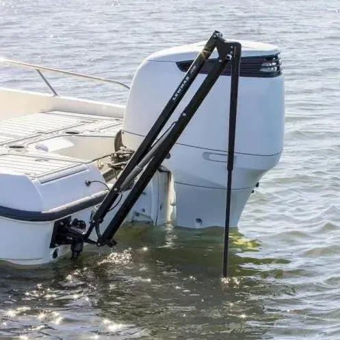 Black Lewmar Axis electric shallow water anchor mounted on a white boat with an outboard motor.