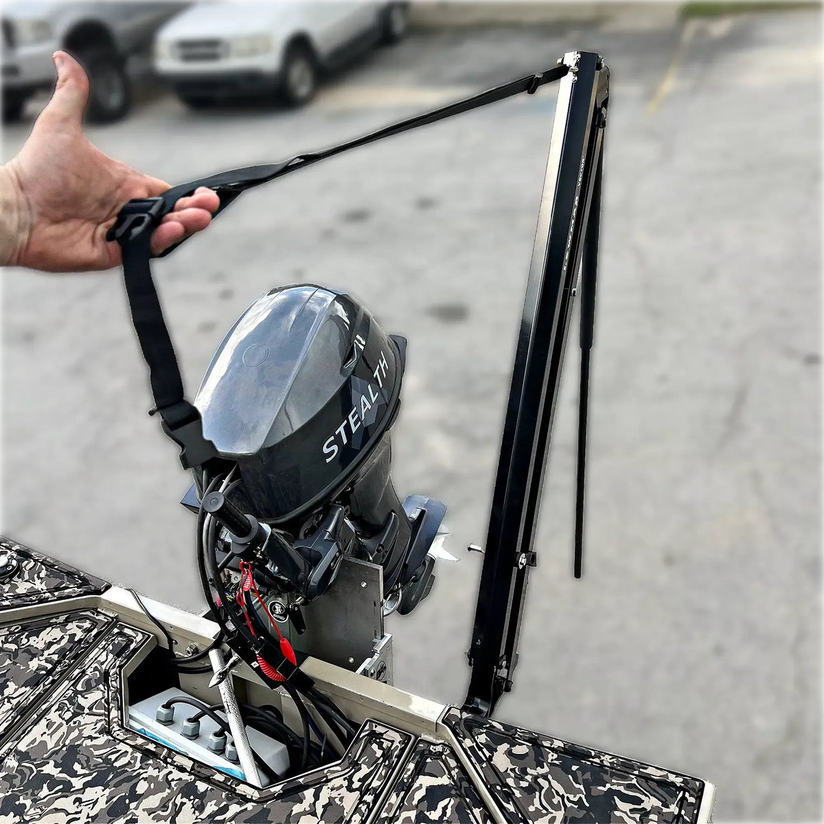 Black Lewmar Vector manual shallow water anchor on a camo jon boat transom, next to a "STEALTH" outboard.