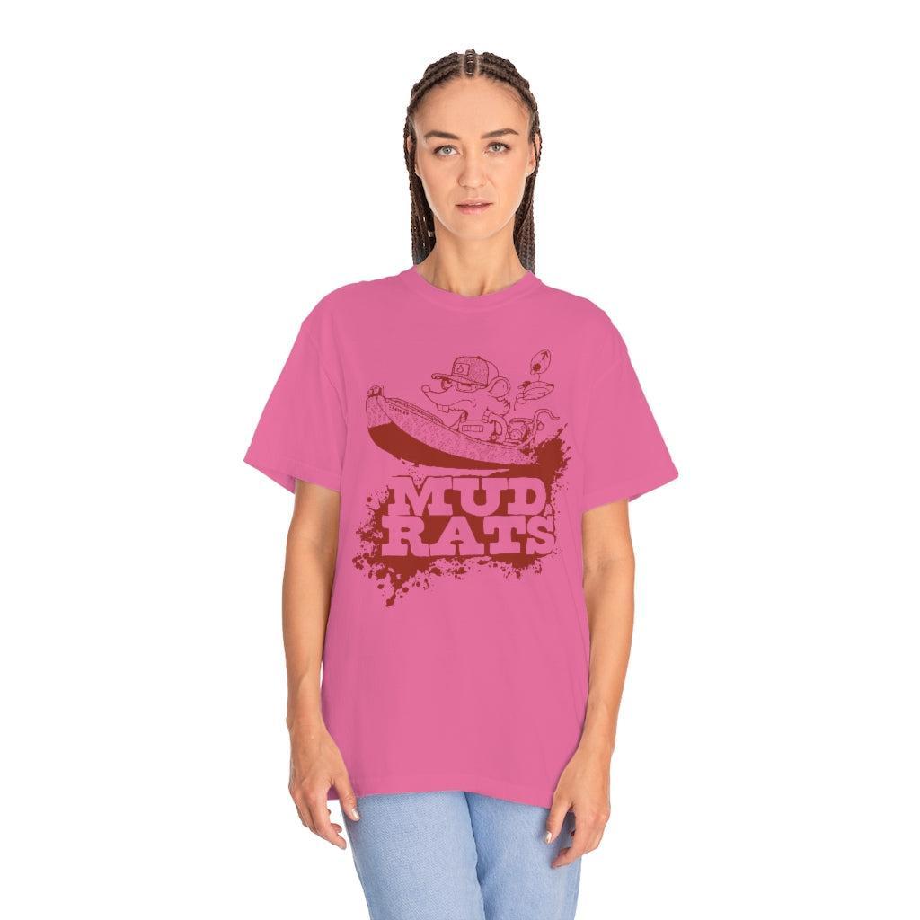 A woman modeling a bright pink t-shirt with a dark red graphic of a mud rat and the text 'MUD RATS' on the front, paired with light blue jeans against a plain white background.