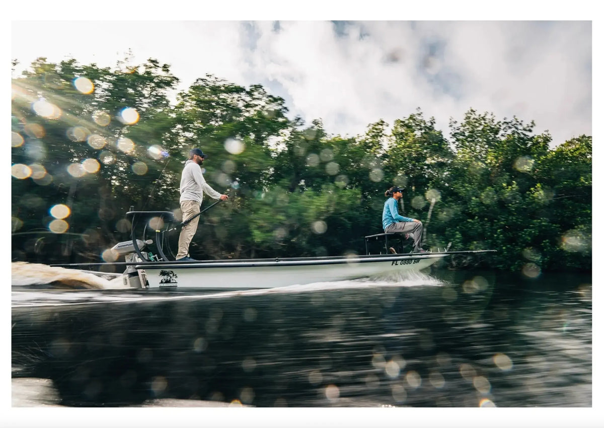 Newport NT600 6hp electric outboard on a white jon boat with two people, cruising through mangroves.