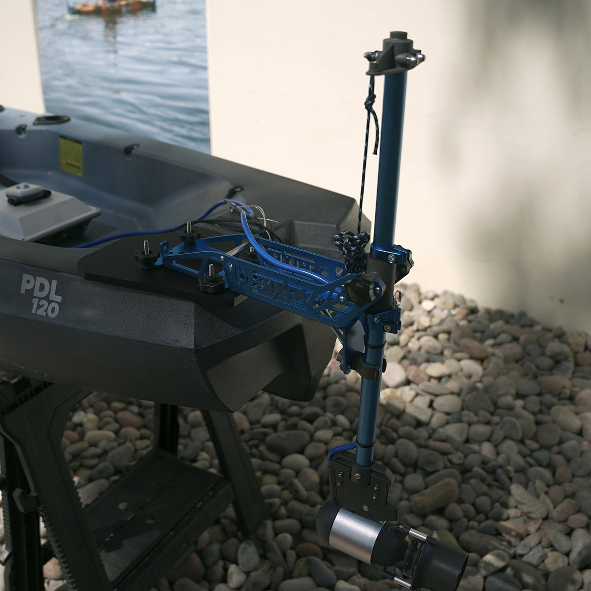 Motorized fishing reel on a boat with water and rocks in the background