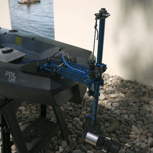 Motorized fishing reel on a boat with water and rocks in the background