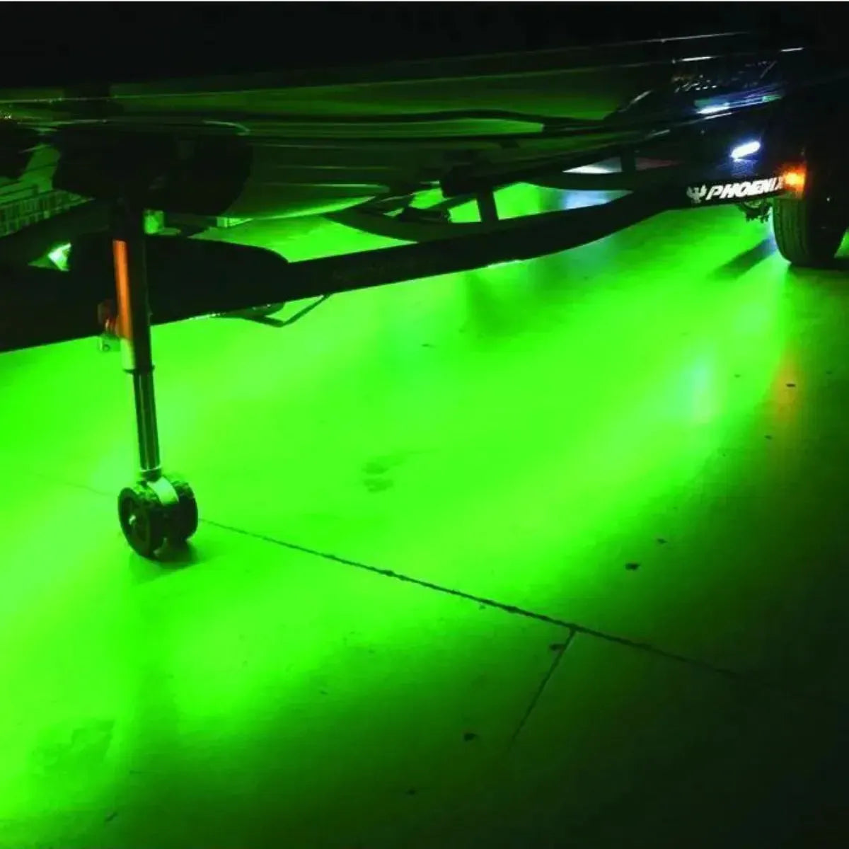 Green LED PlashLights illuminating the ground beneath a boat trailer, showcasing the flexible light strips.