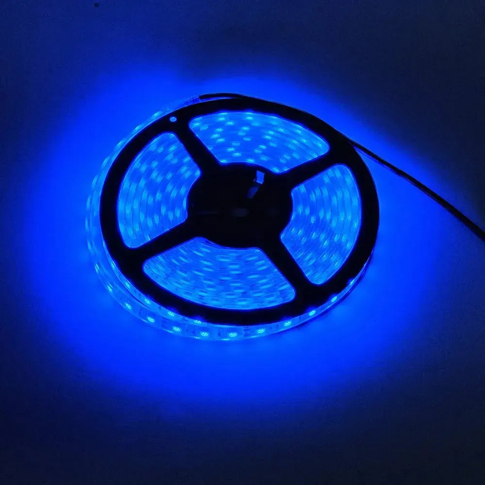 Spool of bright blue LED flexible light strip, glowing intensely in a dark setting.