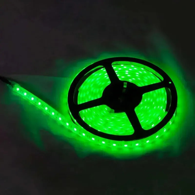 Green LED light strip on a black reel, glowing brightly in the dark.