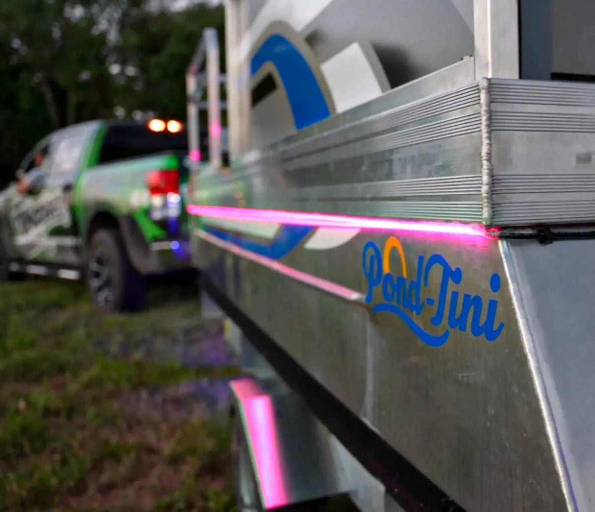 Pink Plashlight RGBW flexible light strip illuminating the side of a "Pond-Tini" pontoon boat.