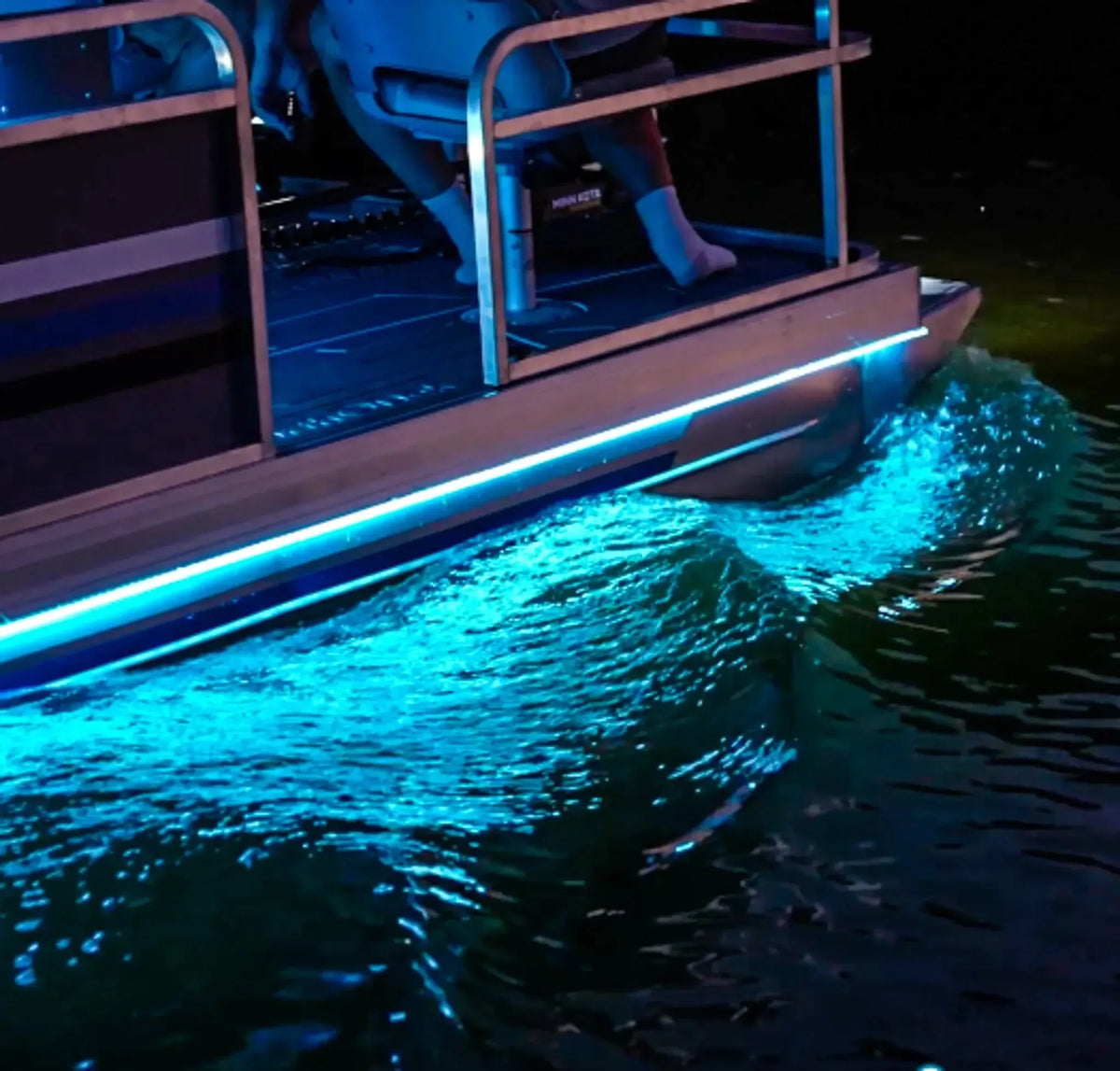 Plashlight 12V RGBW flexible light strip illuminating a boat's hull with bright blue light on water.