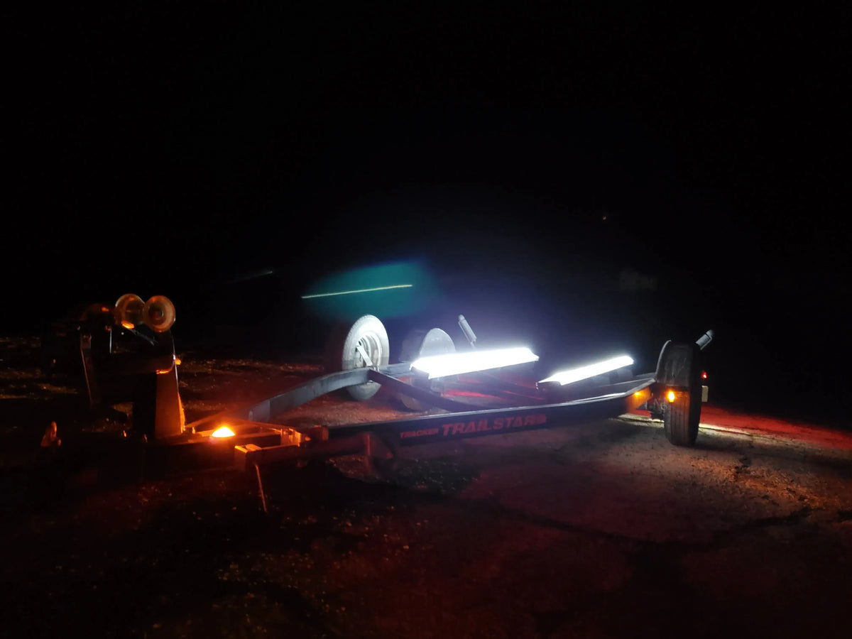 Boat trailer at night with bright white Plashlight LED strips illuminating the bunk boards.