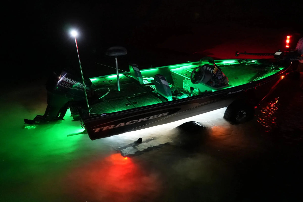 Tracker boat at night with bright green deck and underwater LED lights, plus red stern lights.