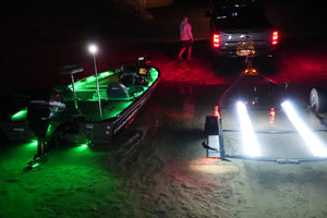 Green LED light strips illuminate a boat and white LED strips light a trailer at night.