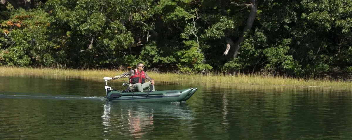 Man fishing from a Hunter Green Sea Eagle 285 Frameless Pontoon Boat with a trolling motor on a calm lake.