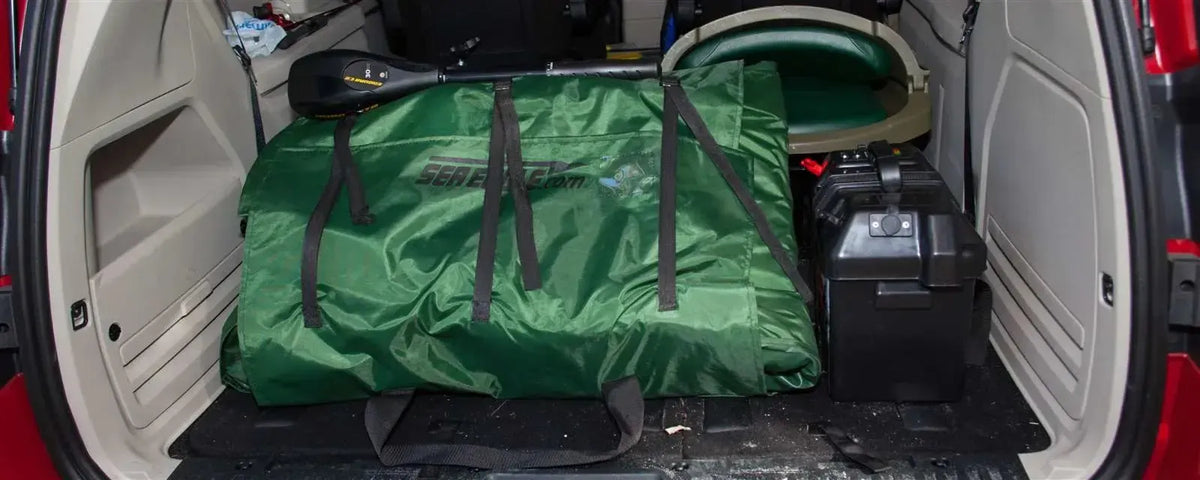 Hunter Green Sea Eagle 285 frameless inflatable fishing boat, folded and packed in a car trunk.