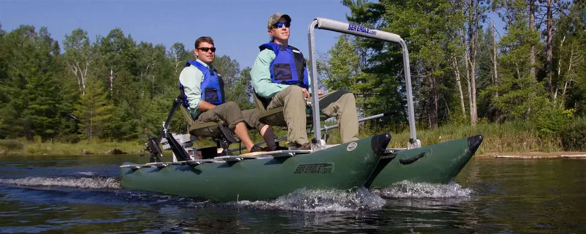 Two men in life vests on a dark hunter green Sea Eagle 375fc FoldCat inflatable fishing boat on a lake.